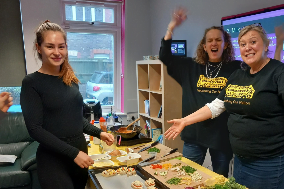 Resident and harvest staff smiling as they make bruschetta