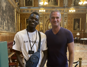 Nader, nominated for Young Leader Award, standing in the Houses of Parliament with MP Peter Kyle