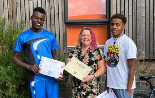 Nader, Jessica (Inspire Coach) and Temesgen stood in the garden holding up their certificates for volunteering