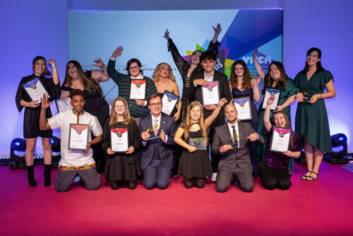 The young finalists at the Youth Matters Awards in 2023. Temesgen is sat on the right, holding his certificate with his other fist in the air. 