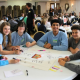 A group of young people in blue school uniform sat on a table at the Mental Health Champions celebration event.