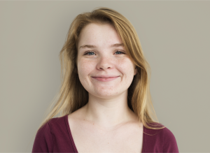 Stacy, a teenage girl with blonde hair smiling, wearing a red top.