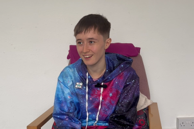 Vivian smiling, wearing a space patterned hoodie